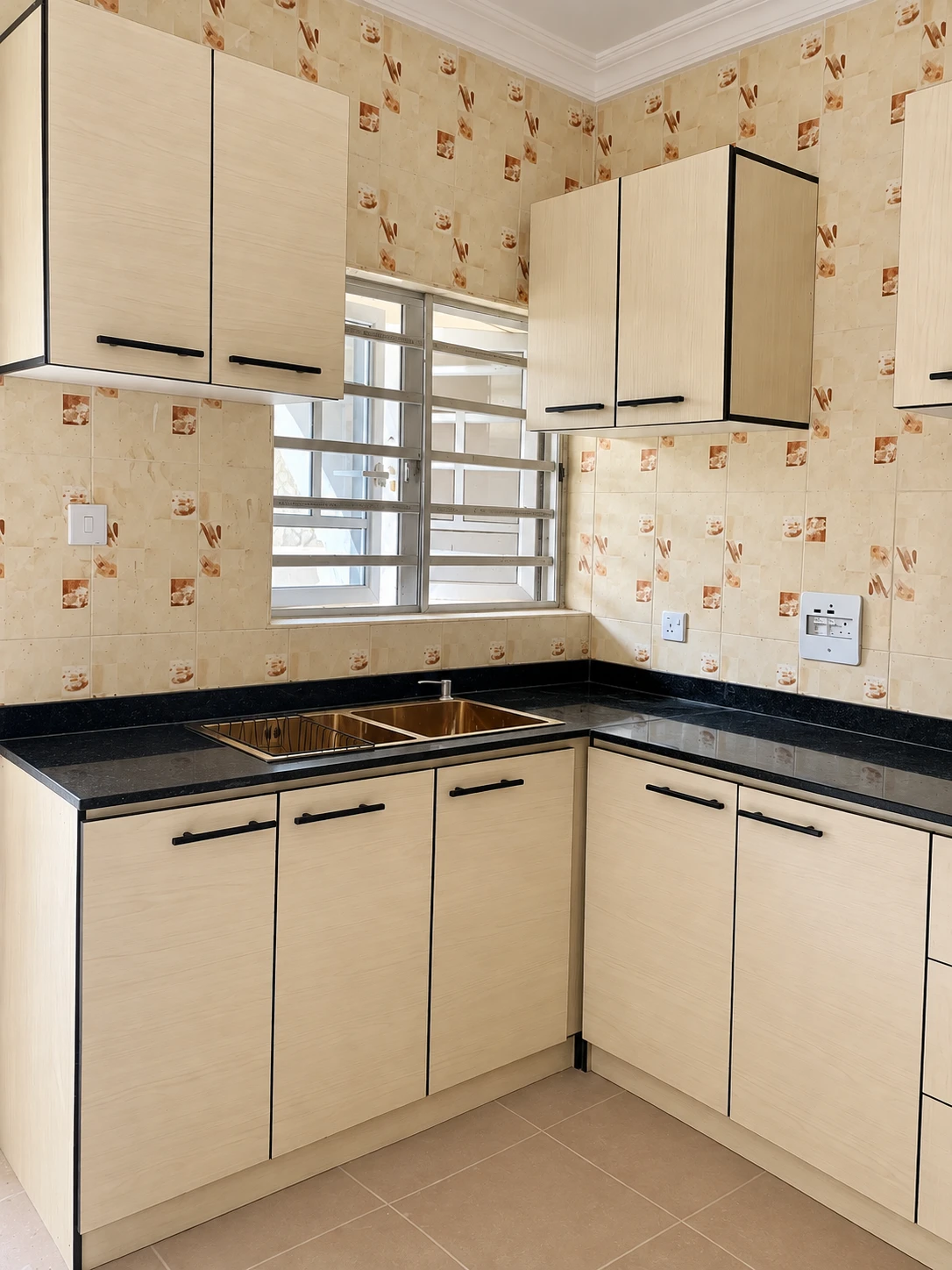 Kitchen corner with sink, cream cabinet doors and black granite countertop