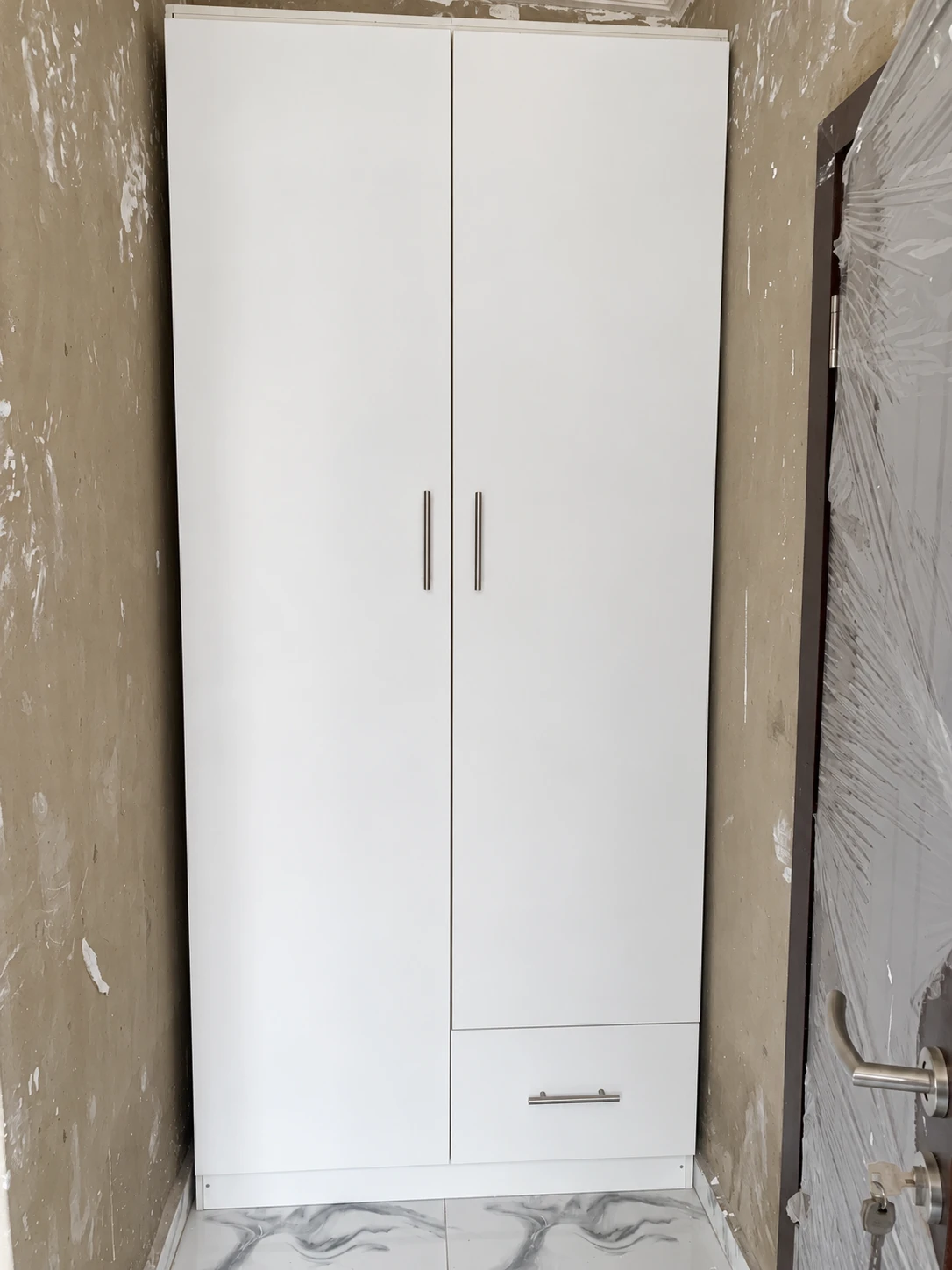 White two-door wardrobe with brushed steel handles and a bottom drawer