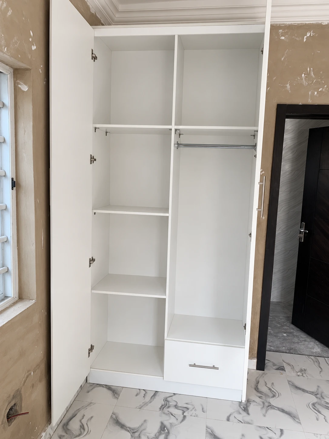 Inside the two-door wardrobe: shelves on one side, hanging rail and drawer on the other